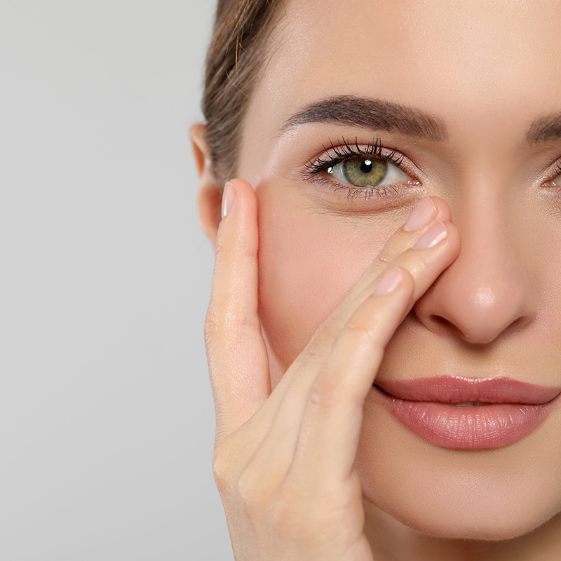 Young woman with cream around eye